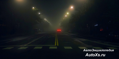 Ночная улица и задние фонари обозначающие автомобиль